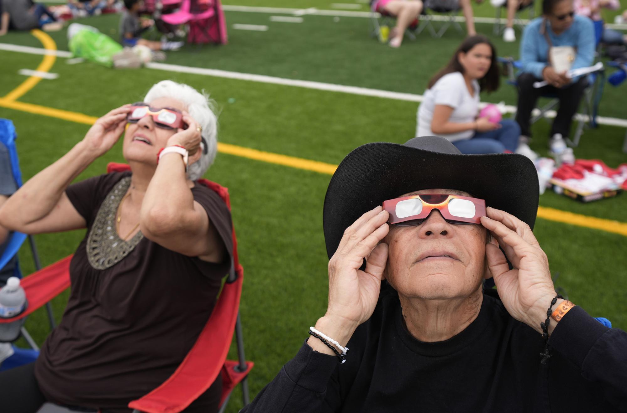 Al Angel Flores, 79, uses special glasses to watch as the moon partially covers the sun during a total solar eclipse, as seen from Eagle Pass, Texas, Monday, April 8, 2024. (AP Photo/Eric Gay)