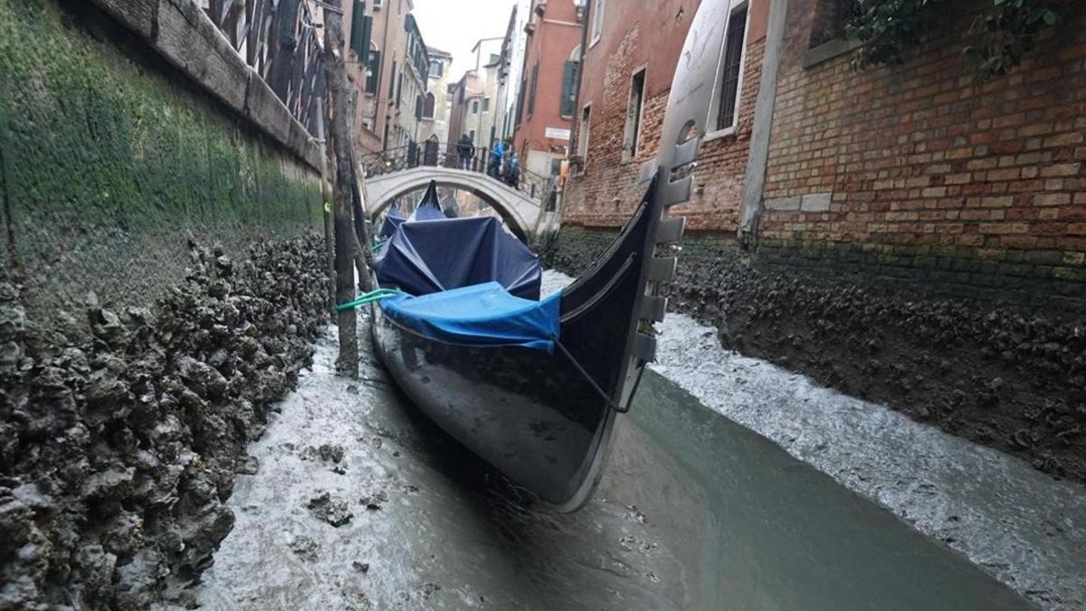 Una góndola en un canal prácticamente si agua.