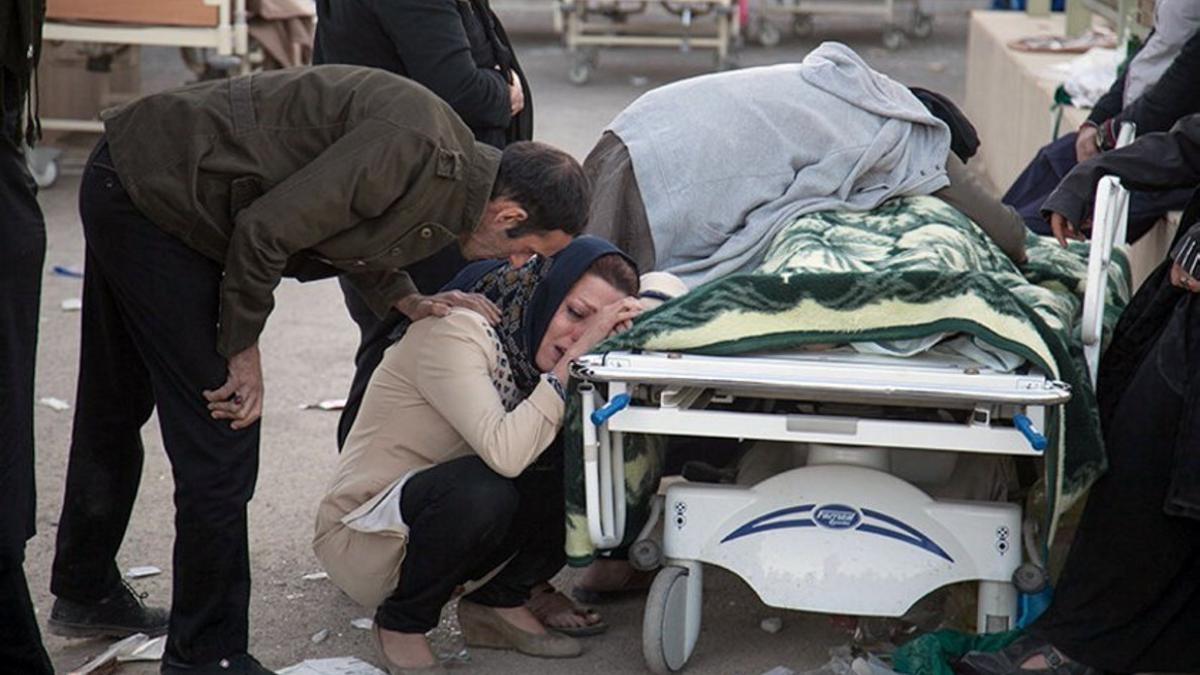 Una mujer llora ante el cadáver de un familiar, en Kermanshah (Irán), este lunes.