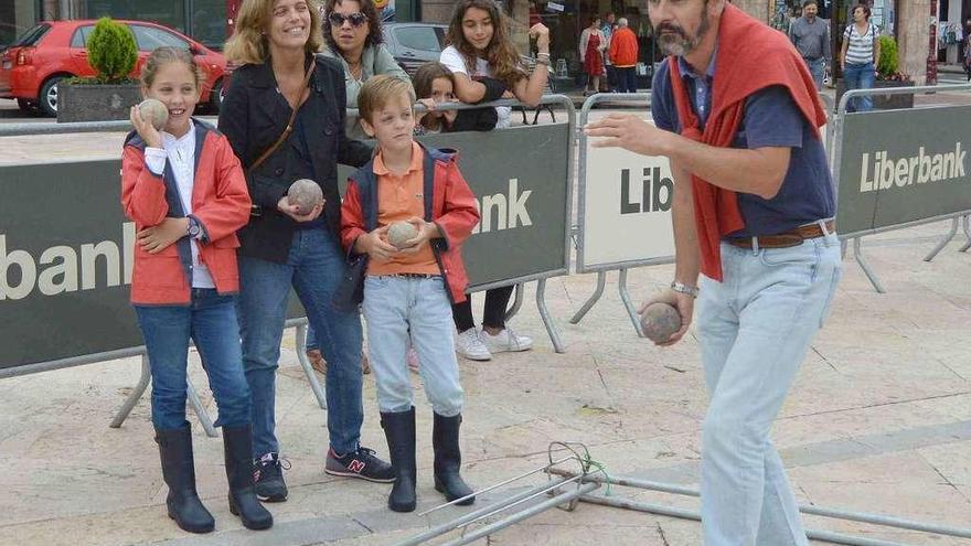 Ramón Moreno a punto de lanzar ante la atenta mirada de su mujer, Patricia, y su hijos, Ramón y Patricia, ayer, en la bolera portátil en Villaviciosa.