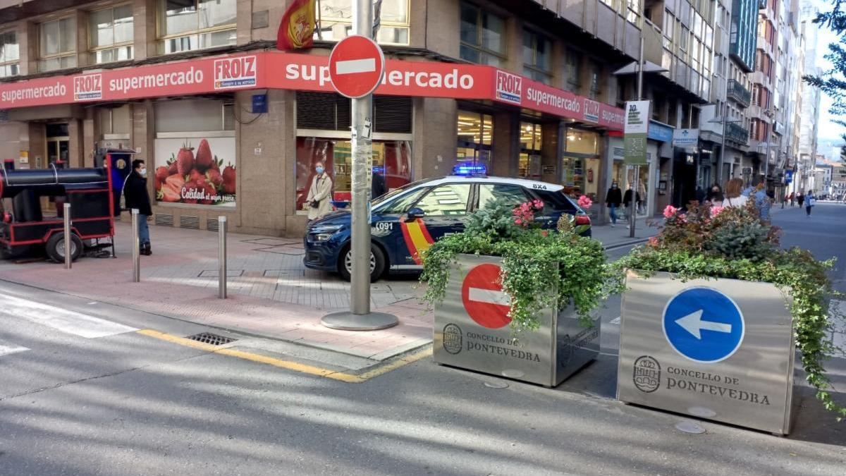 Una patrulla de Policía ante los obstáculos que bloquean el tráfico en Benito Corbal