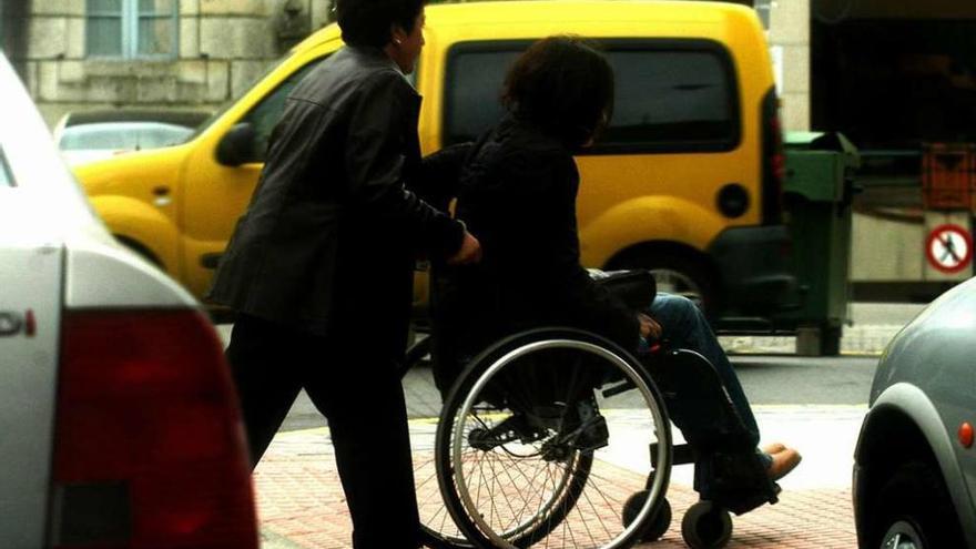 Una mujer empuja a una joven en una silla de ruedas.