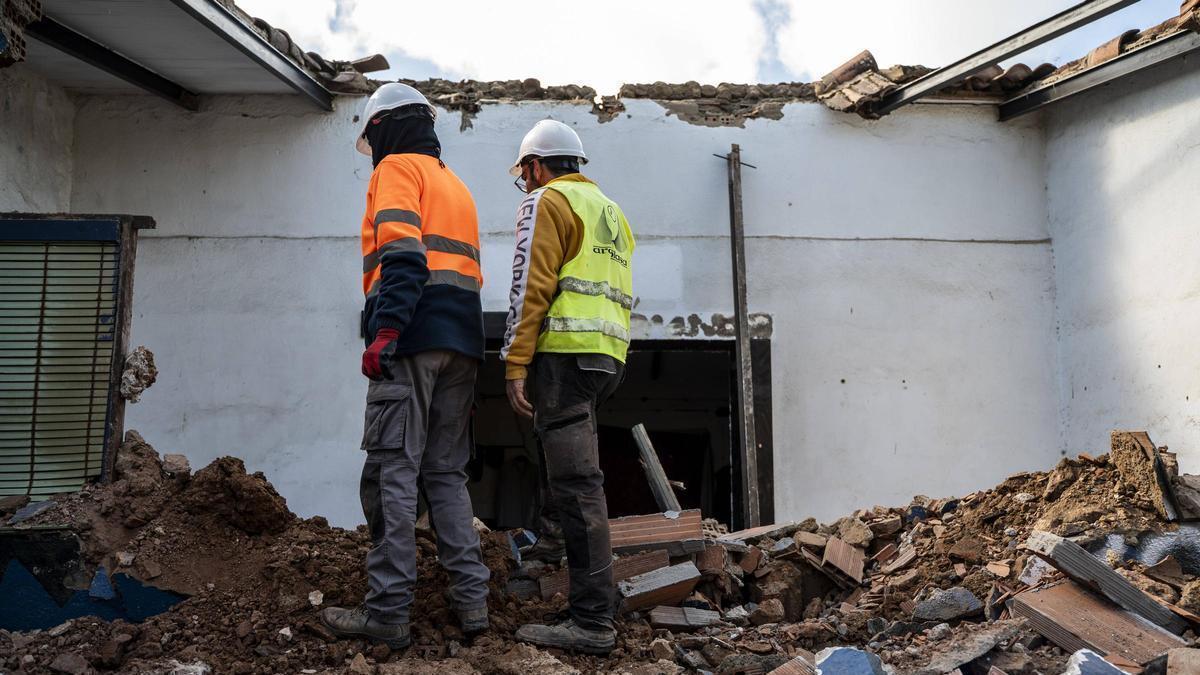 Operarios trabajan entre los restos de una vivienda derribada.