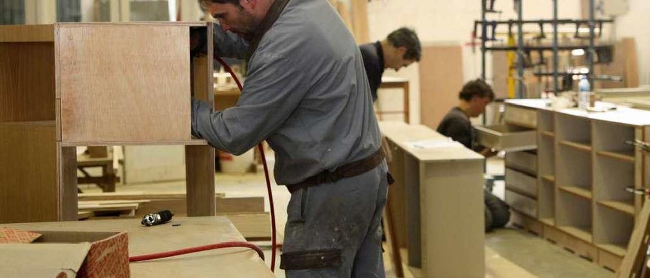 Imagen de archivo de operarios, desarrollando su labor en una fábrica de muebles de A Estrada. // Bernabé
