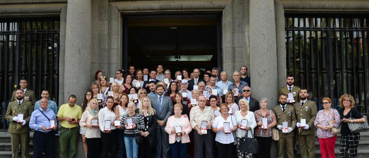 Foto de familia de las víctimas del terrorismo con sus condecoraciones, ayer, frente a la Delegación del Gobierno.