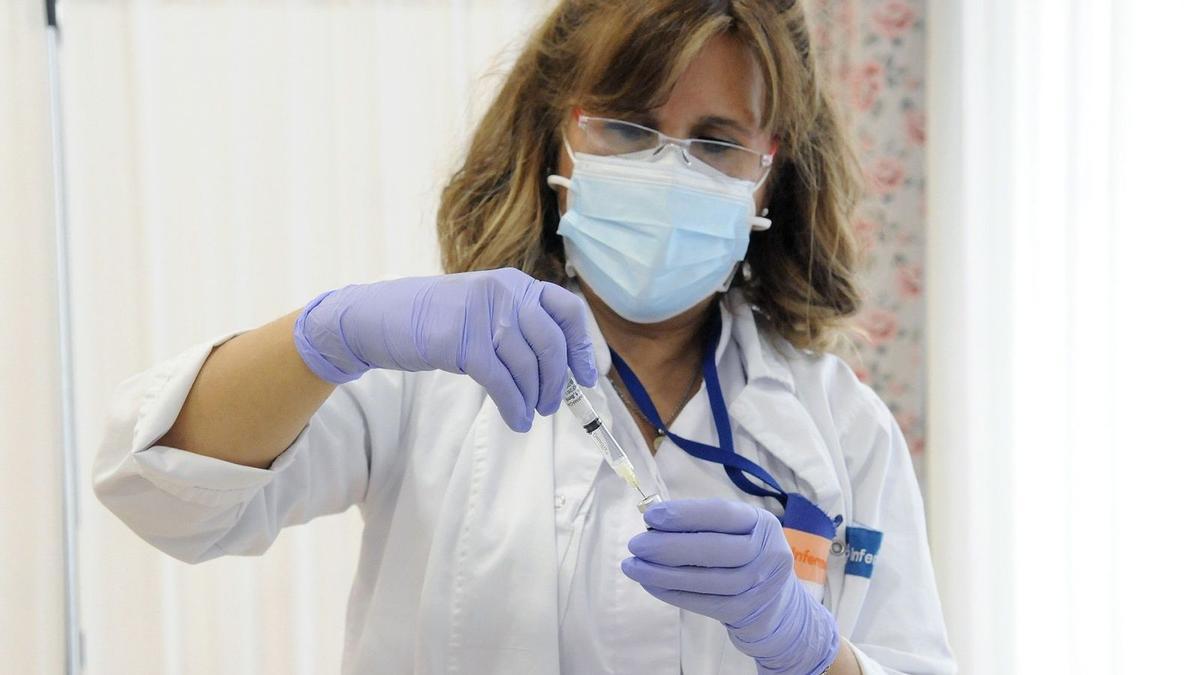 Una enfermera prepara una vacuna.
