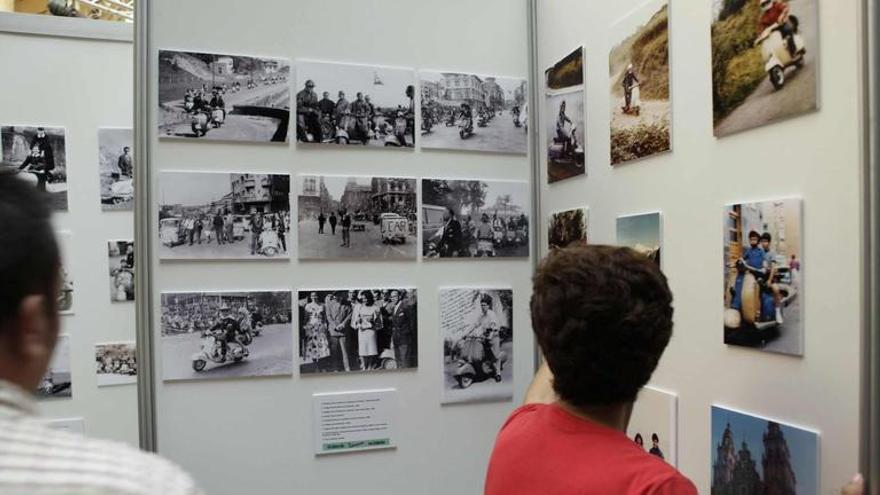 Visitantes observando la exposición &quot;60 años de Vespa en Asturias&quot;.