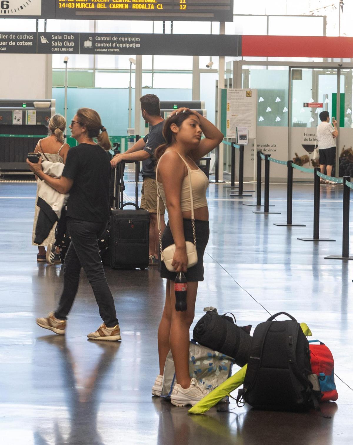 Una joven con mochila y sombrilla en la estación de Alicante.
