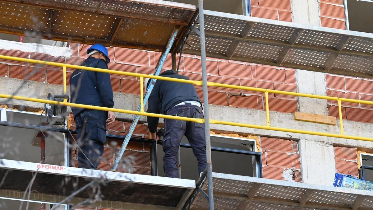 Dos operarios en la construcción de un bloque de viviendas en Castelló