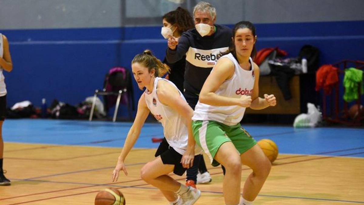 Maddy Hatch conduce el balón ante María Castro bajo la supervisión de Miguel Ángel Luque durante una sesión de entrenamiento del Dobuss en Cervantes.