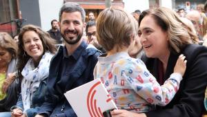 Ada Colau abraza a su hijo en un acto de campaña en el barrio de Gràcia. 