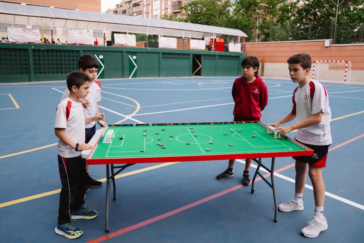 Niños juegan al fútbol chapa en el Colegio Claret de Madrid.