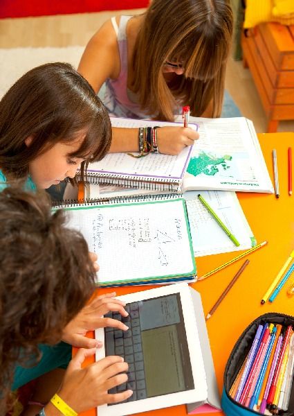 Un niño utiliza la tablet junto a otras compañeras.