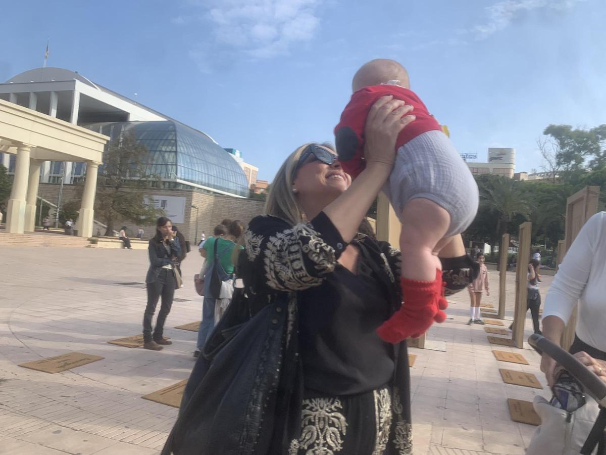 Mariló, familia de acogida, coge en brazos a Alejandro.