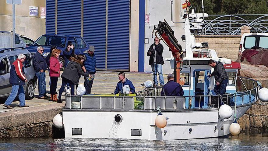 Un barco de artes menores se prepara en un puerto gallego antes de partir.