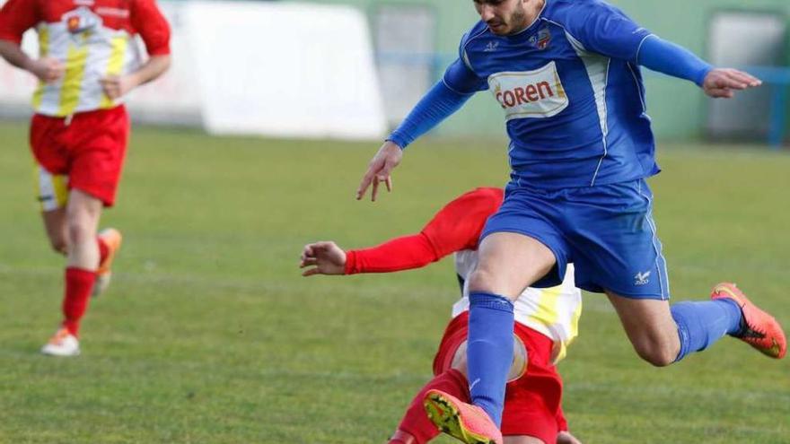 Un jugador del Porriño salva la entrada de un rival del Alertanavia, ayer en O Lourambal. // Ricardo Grobas