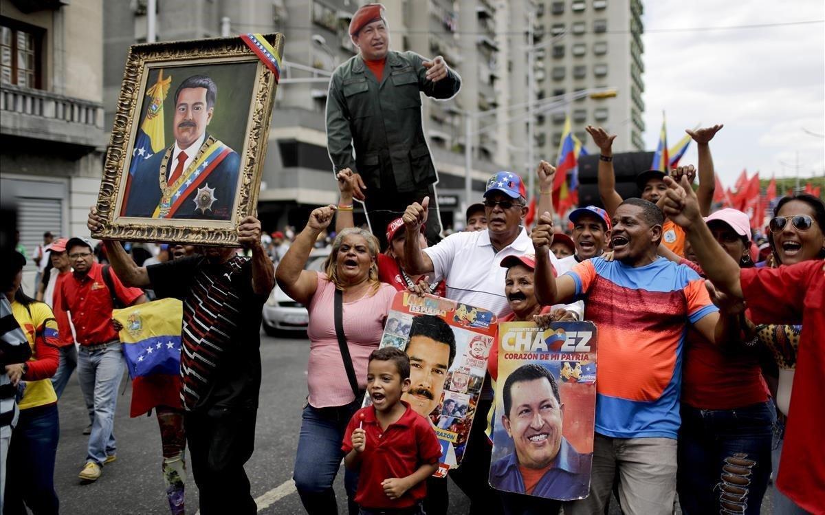 Los partidarios del gobierno llevan imágenes que representan al presidente de Venezuela, Nicolás Maduro, y al fallecido presidente Hugo Chávez, durante una marcha antiimperialista que exige la paz en Caracas, Venezuela.