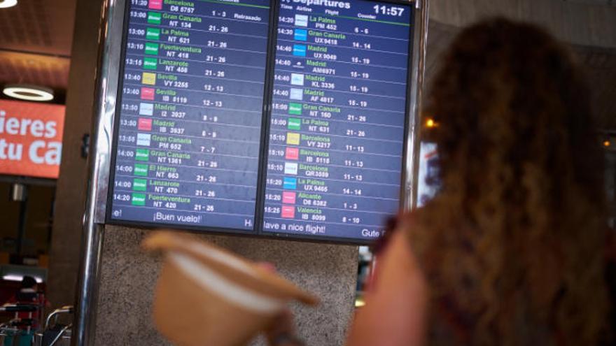 Una mujer mira el panel de vuelos en el aeropuerto de Los Rodeos.