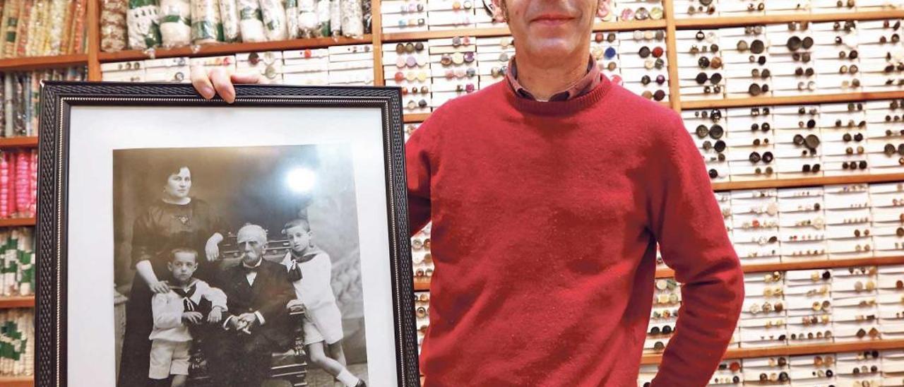 Aguiló Pujades, en el interior de la mercería, muestra la foto del bisabuelo, Ramon Aguiló, junto a sus dos nietos, Ramon, padre del que fuera alcalde de Palma, Ramon Aguiló, y Pep, padre de Miquel. Detrás, de luto, Ángela, abuela del que regenta el negocio.