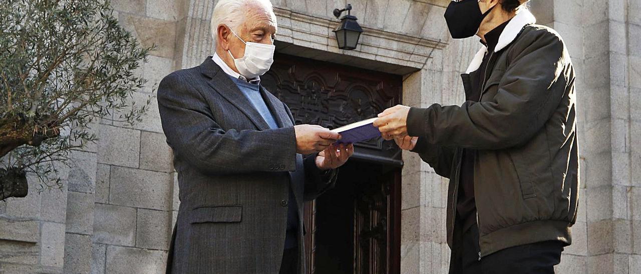 Giráldez (derecha.) entrega un ejemplar del libro a Alonso, actual párroco del templo.   | // ALBA VILLAR