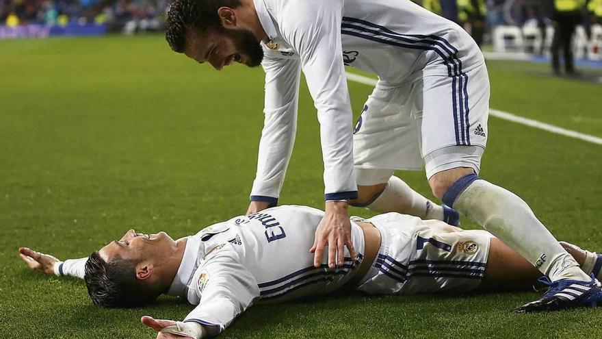 Nacho celebra con Cristiano Ronaldo, en el suelo, el gol del portugués a la Real Sociedad. // Reuters