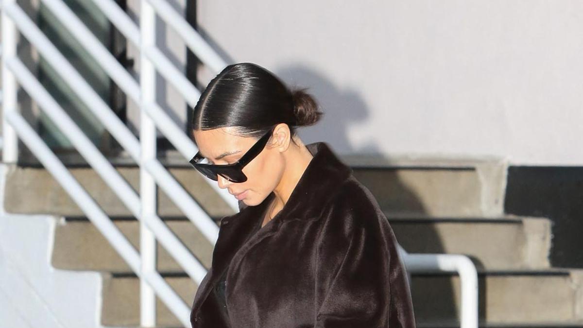 Kim Kardashian con abrigo marrón y gafas de sol de noche