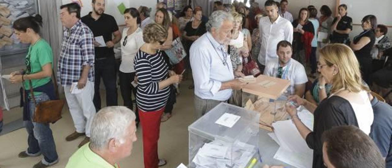 Un hombre vota mientras decenas de personas esperan su turno en un colegio electoral en 2015.