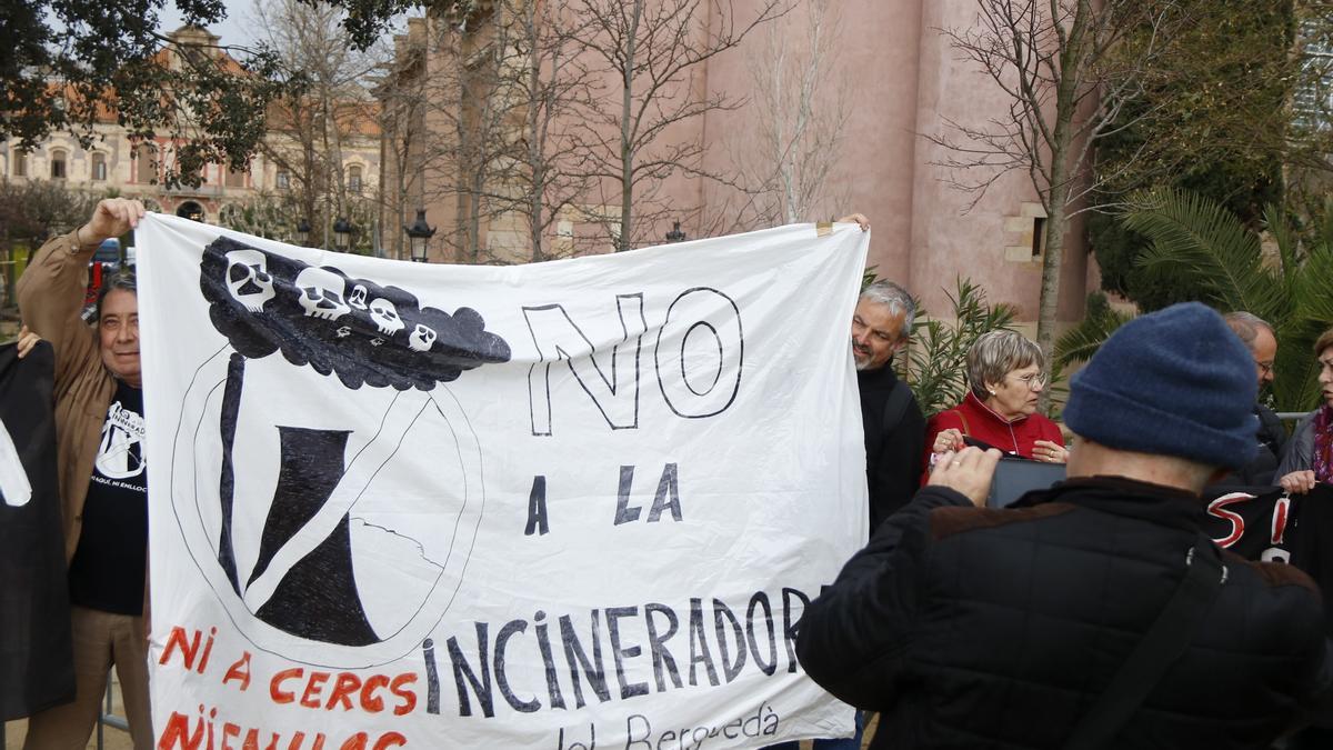 Un home fent una fotografia a una pancarta contra el Departament de Territori per la gestió d&#039;incineradores i abocadors, davant el Parlament