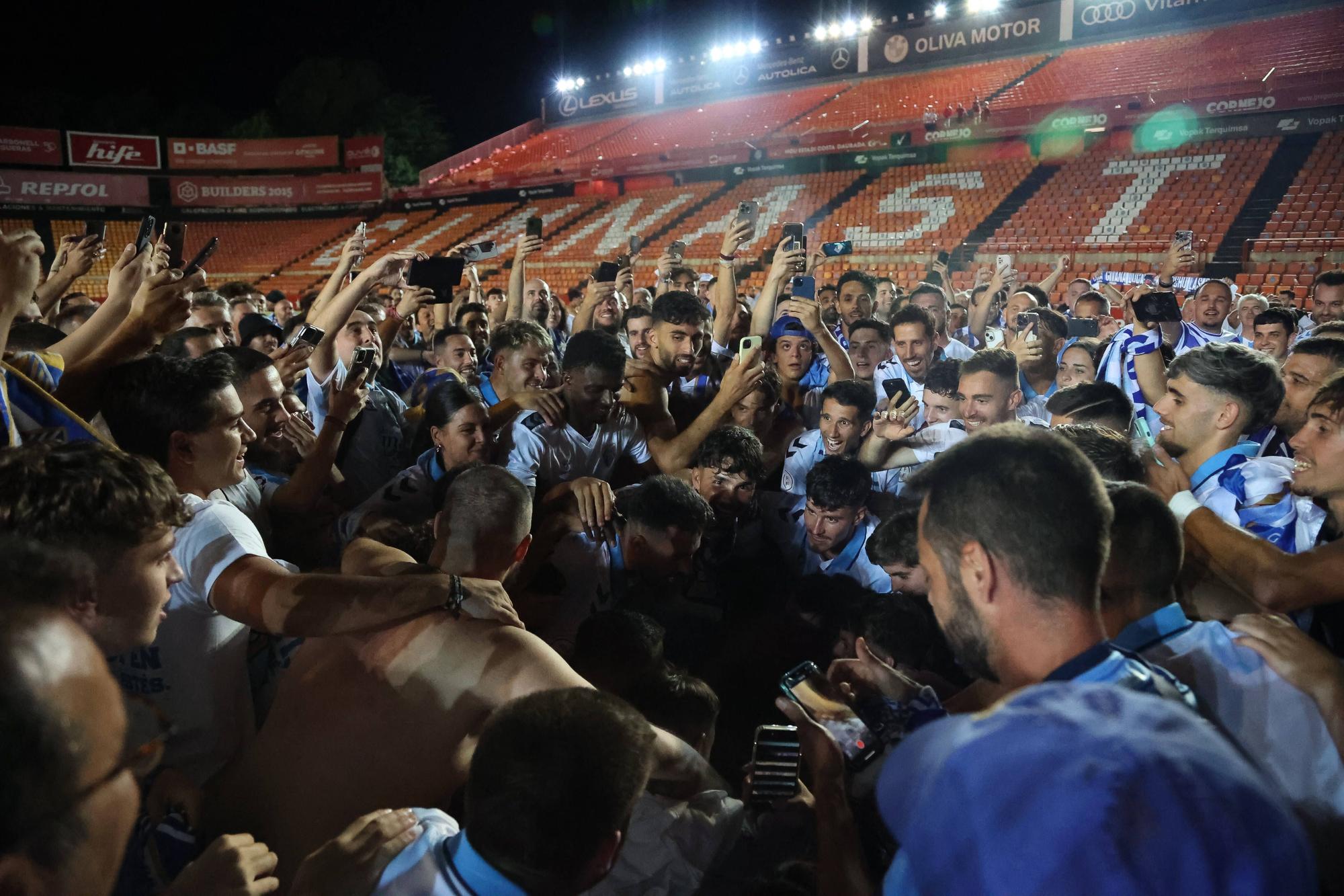 Los más de 500 aficionados del Málaga CF que estuvieron en el Nou Congost celebraron con los jugadores el épico ascenso a Segunda tras el final del partido