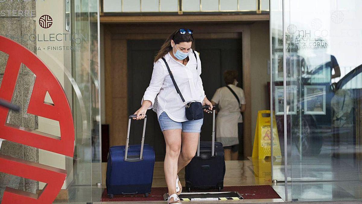 Una turista sale ayer del Hotel Finisterre, donde siguen en cuarentena los deportistas.