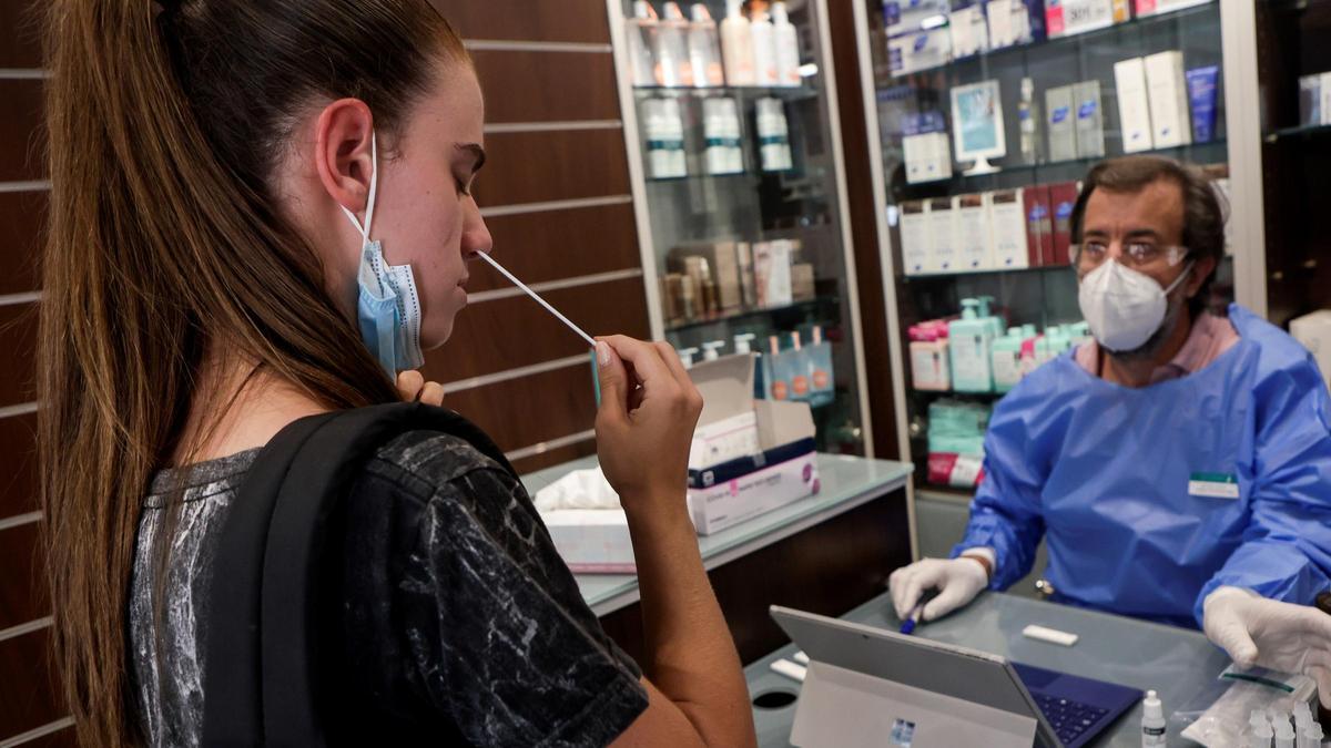 Una joven se hace un autotest en una farmacia.