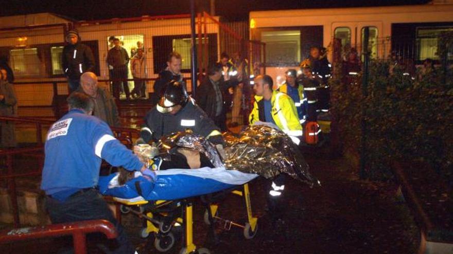 Los bomberos y los servicios médicos atienden a Bibiana Presa, tras sacarla de debajo del tren.