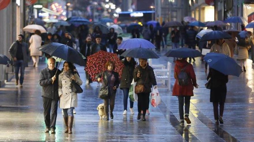 Gente con paraguas en el centro de Vigo // R. GROBAS