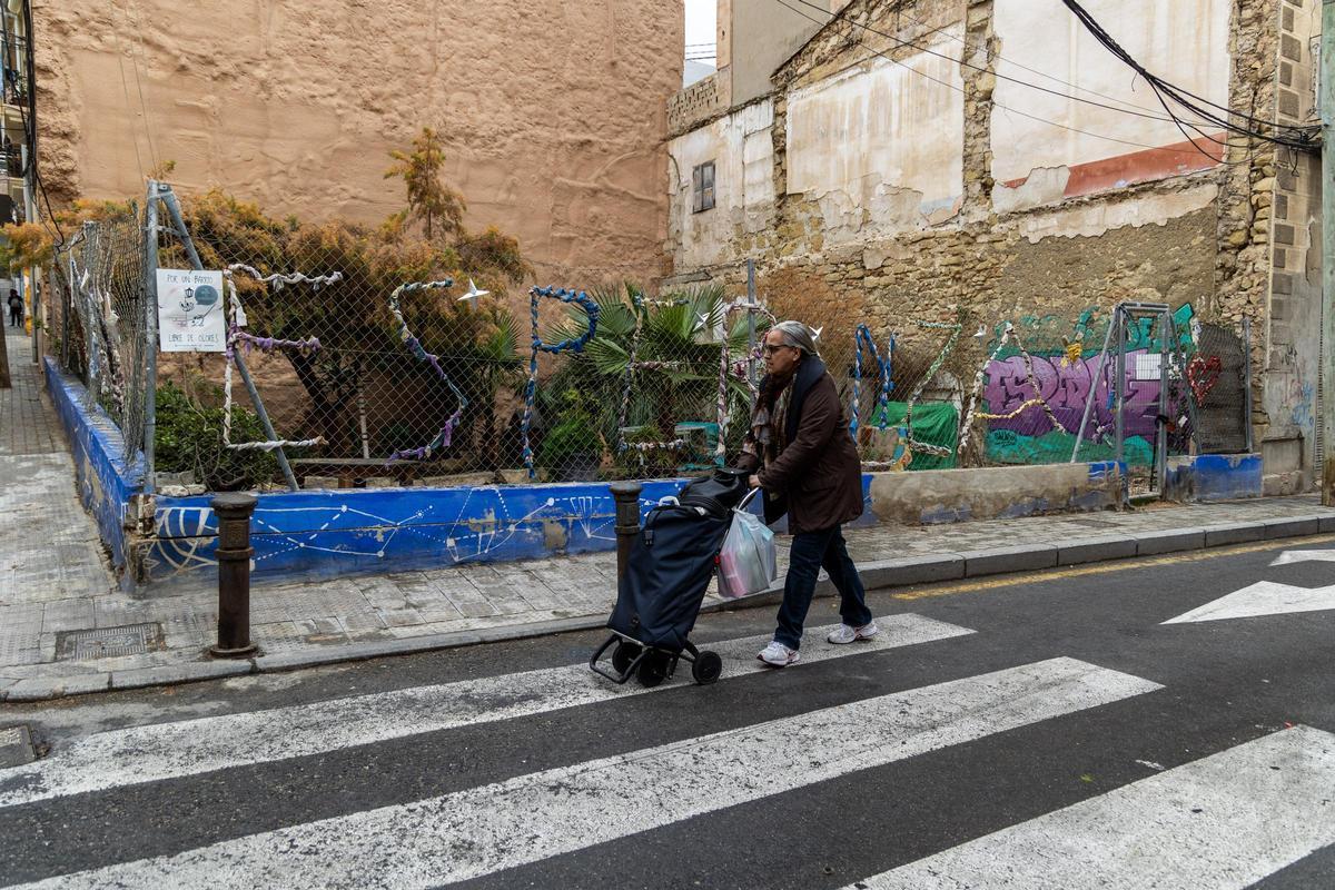 Una persona pasa con su carro por la calzada.