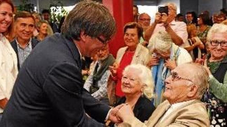 Domènec Fita i Àngela Rodeja saluden el president Puigdemont al local de l&#039;Associació de Veïns de Montjuïc.