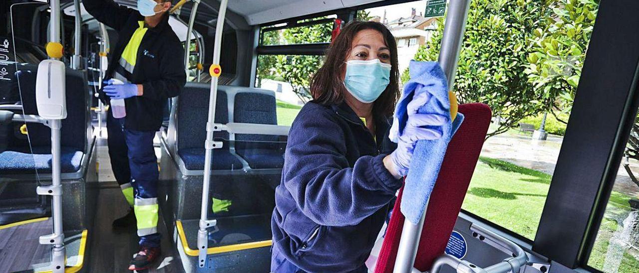 Trabajadores de una contrata municipal desinfectan el interior de un autobús.