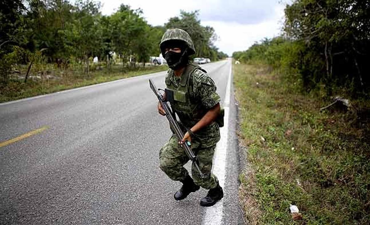 Un soldat corre cap al seu comboi després de fer una operació al ranxo San Juan, als afores de Cancún (Mèxic).