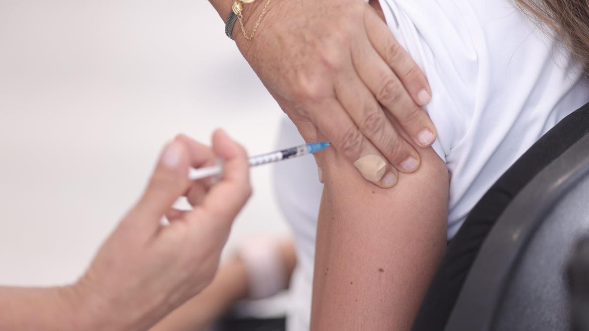 Una sanitaria administrando una vacuna contra la covid a una paciente.