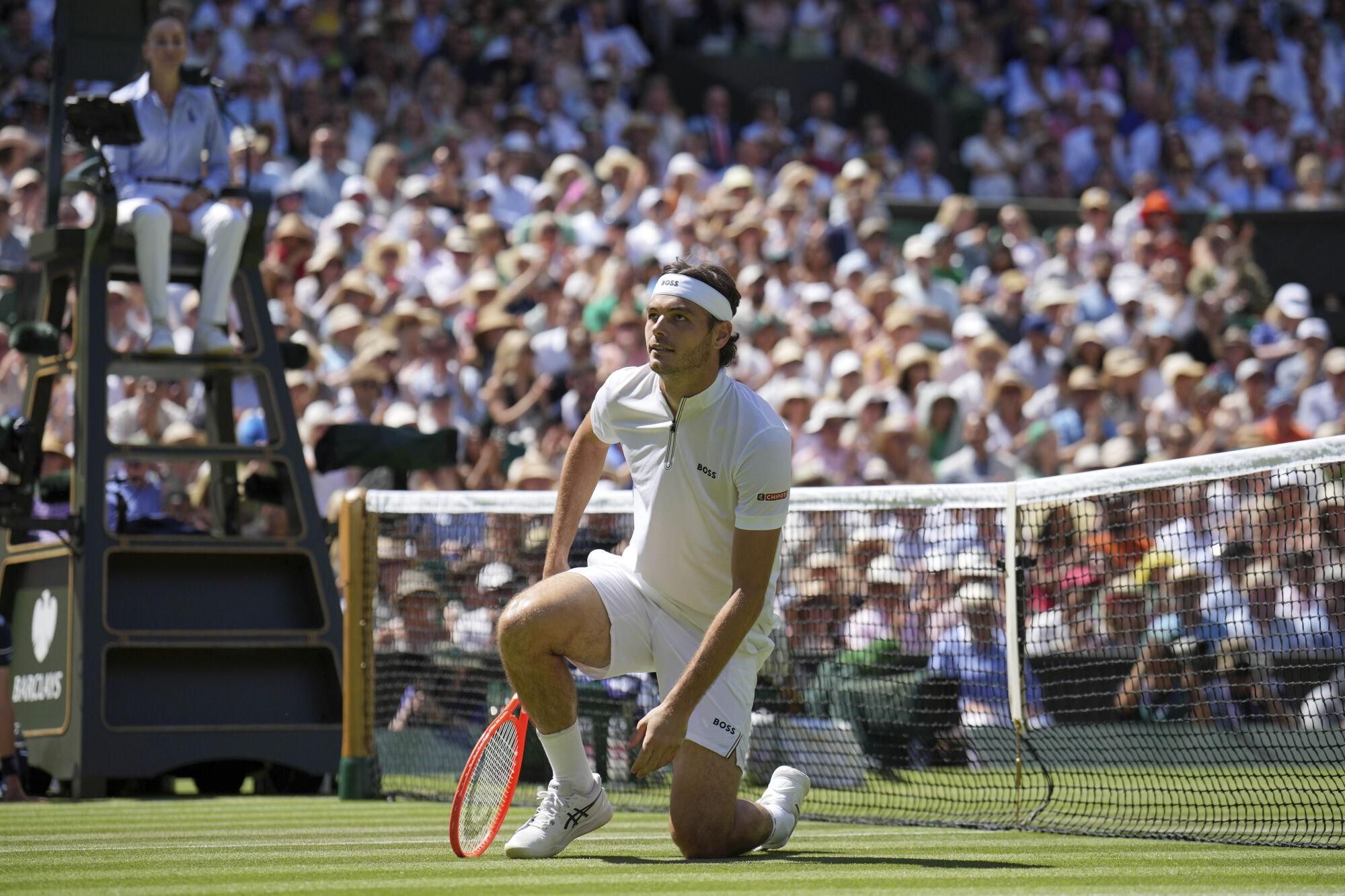 Taylor Fritz of the U.S. gets to his feet after diving to return to Spain's Carlos Alcaraz in a men's singles semifinal at the Wimbledon Tennis Championships in London, Friday, July 11, 2025. (AP Photo/Kin Cheung). EDITORIAL USE ONLY/ONLY ITALY AND SPAIN