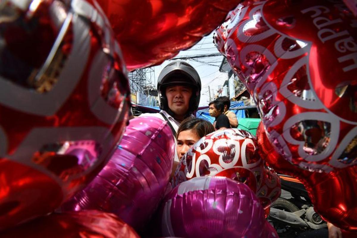 La gente compra ramos de flores el Día de San Valentín en un mercado de flores en Manila