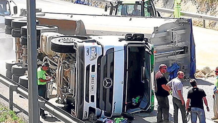 Varias personas, junto al camión volcado ayer en Alcúdia.