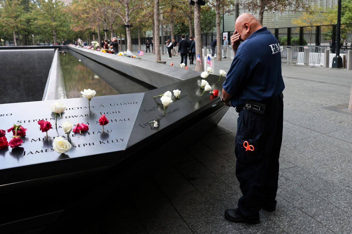 Un miembro de los equipos de emergencia hace una pausa ante el Memorial del 11-S