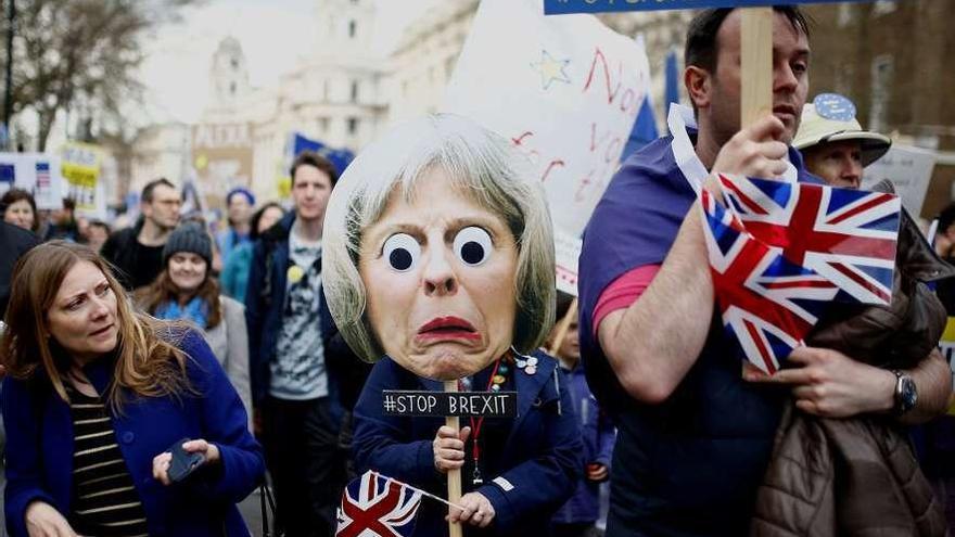 Uno de los participantes porta una pancarta con una caricatura de May. // Reuters