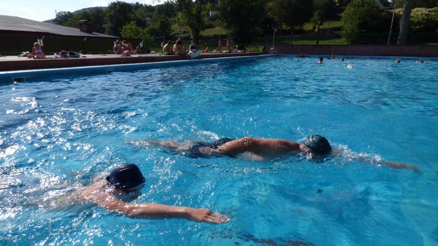 Dos personas nadan en una piscina.