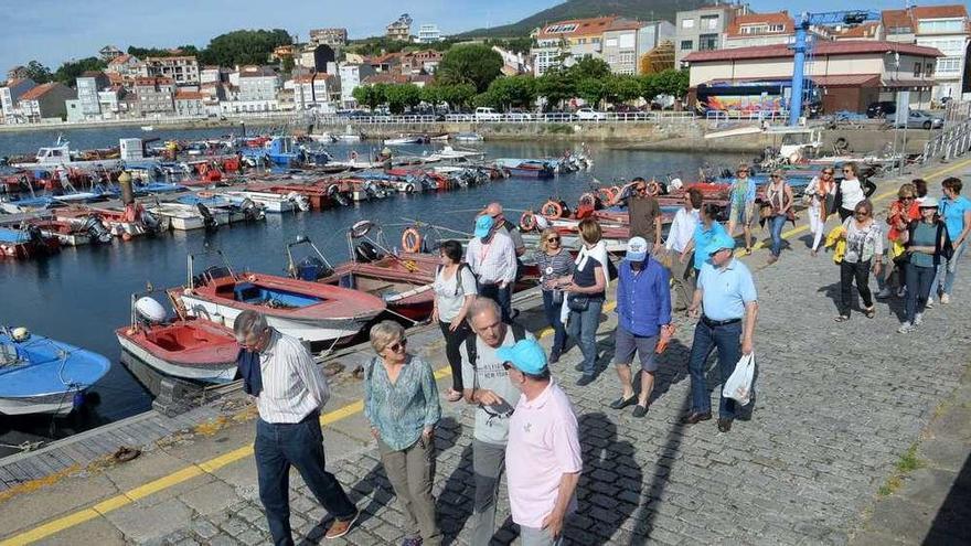 Un grupo de turistas realiza una visita guiada por el puerto y las zonas marisqueras de Carril. // Noé Parga
