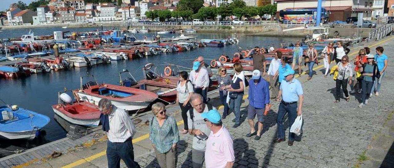 Un grupo de turistas realiza una visita guiada por el puerto y las zonas marisqueras de Carril. // Noé Parga