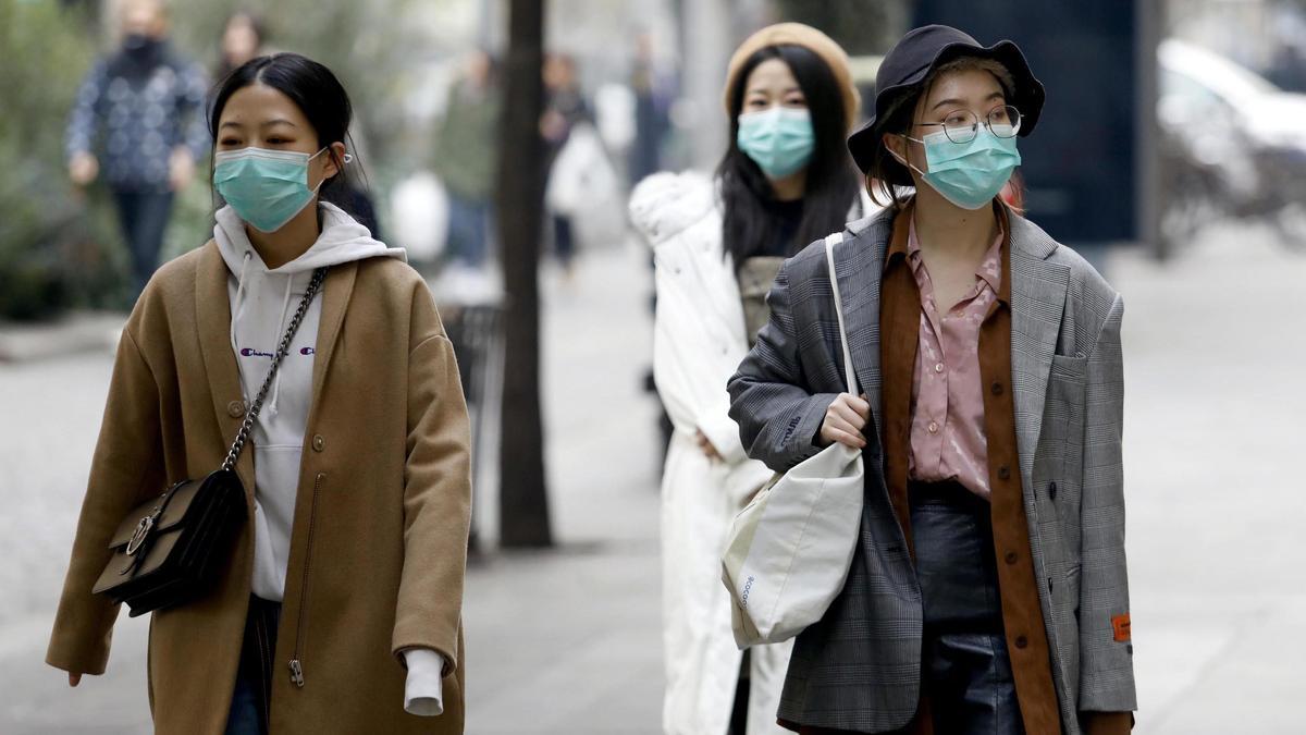 Mujeres chinas pasean con mascarilla