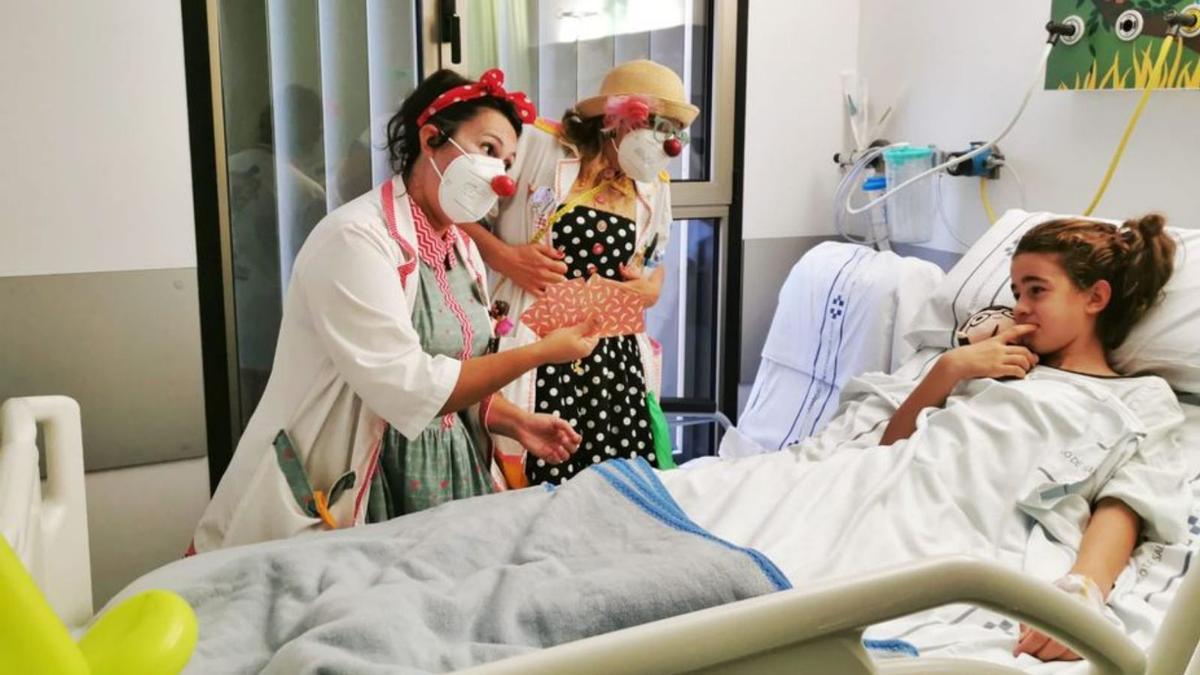 Dos payasas de Hospitran visitan a una niña en el hospital majorero. | | HOSPITRAN