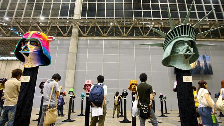 Un grupo de visitantes observan una muestra de máscaras de ´Star Wars´ durante la celebración de la saga en Makuhari, Japón. Durante los tres días que dura el evento, unos 20 mil seguidores participarán de la fiesta.