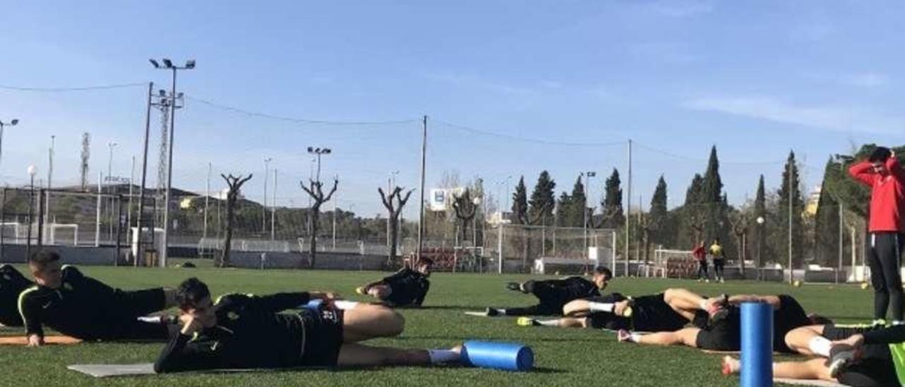 Los jugadores del Sporting estiran al término del entrenamiento de ayer en Paterna.